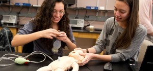 CBID Design Gallery. Two students work on an infant mannequin