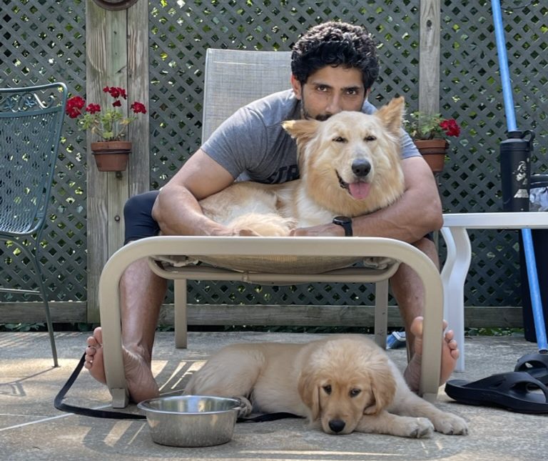Sunil with two dogs on a lawn chair